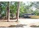 A charming single-story home with a gray brick facade and a fenced-in yard surrounded by lush greenery at 9218 Memorial Hwy, Tampa, FL 33615