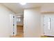 Inviting hallway with wood floors, white doors, and decorative glass window on the front door at 9218 Memorial Hwy, Tampa, FL 33615
