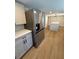 This updated kitchen features stainless steel appliances, quartz counters, white cabinetry, and wood-look flooring at 9218 Memorial Hwy, Tampa, FL 33615