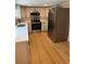 Updated kitchen features stainless steel appliances, quartz counters, white cabinetry, and wood-look flooring at 9218 Memorial Hwy, Tampa, FL 33615