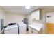 Functional laundry area with white cabinets, washer, dryer, and modern finishes at 9218 Memorial Hwy, Tampa, FL 33615