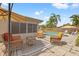 Outdoor patio area with wicker furniture, umbrella, and a view of the pool and backyard at 9309 120Th St, Seminole, FL 33772