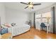 A bedroom with a ceiling fan and window with a desk and hardwood floors at 9309 120Th St, Seminole, FL 33772