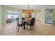 Open dining room featuring a glass table, chandelier, and view into the living room and kitchen at 9309 120Th St, Seminole, FL 33772
