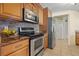Kitchen featuring tile backsplash, stainless steel appliances and wood cabinets at 9309 120Th St, Seminole, FL 33772