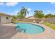 Backyard features a private pool surrounded by brick pavers, a wooden fence, and lush green landscaping at 9309 120Th St, Seminole, FL 33772