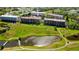 Wide aerial view of the community with pond, green spaces and condo buildings at 9461 Harbor Greens Way # 502, Seminole, FL 33776