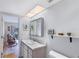 Bathroom with a white vanity, wall-mounted mirror and light, with a view into the adjacent living area at 9461 Harbor Greens Way # 502, Seminole, FL 33776