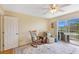 Bright bedroom with a sitting area, large area rug, and sliding doors leading to a screened balcony at 9461 Harbor Greens Way # 502, Seminole, FL 33776