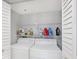 Laundry area featuring a white washer and dryer with cleaning supplies stored on shelving above at 9461 Harbor Greens Way # 502, Seminole, FL 33776