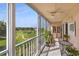 Enclosed balcony featuring a variety of plants and furniture, with views of a golf course at 9461 Harbor Greens Way # 502, Seminole, FL 33776
