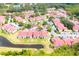 Wide aerial view highlighting numerous red-roofed townhomes with surrounding ponds and mature trees at 9481 Highland Oak Dr # 1310, Tampa, FL 33647