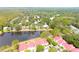 Scenic aerial shot showcasing red-roofed townhomes beside a tranquil lake surrounded by lush trees at 9481 Highland Oak Dr # 1310, Tampa, FL 33647