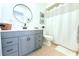 Charming bathroom featuring a vanity with a round mirror and a shower with a white curtain at 9481 Highland Oak Dr # 1310, Tampa, FL 33647