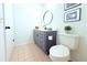 Classic bathroom featuring a vanity with a round mirror and a toilet with a white seat at 9481 Highland Oak Dr # 1310, Tampa, FL 33647