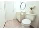 Bright bathroom has vanity with round mirror, toilet, and tiled floors at 9481 Highland Oak Dr # 1310, Tampa, FL 33647
