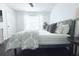Bright bedroom offers wood floors, a gray studded headboard, and curtain covered window at 9481 Highland Oak Dr # 1310, Tampa, FL 33647