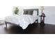 Bright bedroom features hardwood floors, a gray studded headboard and decor on the bedside table at 9481 Highland Oak Dr # 1310, Tampa, FL 33647