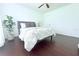 Bright bedroom boasts wood floors, a gray studded headboard, and ceiling fan at 9481 Highland Oak Dr # 1310, Tampa, FL 33647