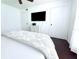 Bright bedroom with white walls, dark floors, mounted TV, and a comfortable bed with a patterned coverlet at 9481 Highland Oak Dr # 1310, Tampa, FL 33647