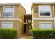 Inviting two-story exterior of a tan condo with a well-maintained front landscape at 9481 Highland Oak Dr # 1310, Tampa, FL 33647