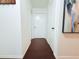 Hallway with dark hardwood floors leads to white doors and an art piece is on the wall at 9481 Highland Oak Dr # 1310, Tampa, FL 33647