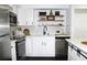 Beautiful white kitchen with open shelving, stainless steel appliances and breakfast bar at 9481 Highland Oak Dr # 1310, Tampa, FL 33647