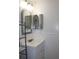 This bathroom features a single sink vanity, an oval mirror, and wainscotting on the lower half of the wall at 9705 45Th N Way, Pinellas Park, FL 33782