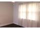 A well-lit bedroom has a large window with sheer curtains, white walls, and dark wood floors at 9705 45Th N Way, Pinellas Park, FL 33782
