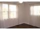 Bright bedroom featuring wood floor and a pair of windows dressed with sheer curtains at 9705 45Th N Way, Pinellas Park, FL 33782
