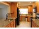 Well-lit kitchen with wood cabinets, granite counters, and modern black appliances at 9705 45Th N Way, Pinellas Park, FL 33782