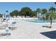 Community pool area featuring palm trees, chairs, and tables under a clear blue sky at 9705 45Th N Way, Pinellas Park, FL 33782