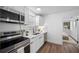Modern kitchen with stainless steel appliances, white cabinets, and laminate flooring at 4626 8Th S Ave, St Petersburg, FL 33711