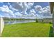 Expansive green lawn leads to a tranquil pond, creating a serene backyard setting at 10308 Malvasia Ave, Riverview, FL 33578