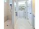 Bright bathroom featuring a tiled walk-in shower and doorway view to an organized walk-in closet at 10308 Malvasia Ave, Riverview, FL 33578