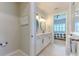 Well-lit bathroom with double vanity and round mirrors, offering a glimpse into an adjacent bedroom at 10308 Malvasia Ave, Riverview, FL 33578