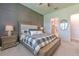 Comfortable bedroom with ceiling fan, wood accent wall, neutral carpet and Primary bathroom entrance at 10308 Malvasia Ave, Riverview, FL 33578