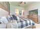Comfortable bedroom with ceiling fan, wood accent wall, neutral carpet and Primary bathroom entrances at 10308 Malvasia Ave, Riverview, FL 33578