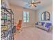 Neutral toned bedroom featuring a desk and sofa, illuminated by natural light and a ceiling fan at 10308 Malvasia Ave, Riverview, FL 33578