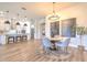 View from dining room with modern hanging lights, into kitchen with stainless appliances and island at 10308 Malvasia Ave, Riverview, FL 33578