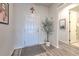Clean foyer boasts a white door, olive tree, religious art, and a glimpse to a bath at 10308 Malvasia Ave, Riverview, FL 33578