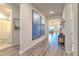 Inviting hallway featuring modern artwork, wood floors, and an archway leading to the living areas at 10308 Malvasia Ave, Riverview, FL 33578