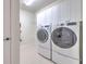 Functional laundry room with modern, white appliances and ample storage space for convenience at 10308 Malvasia Ave, Riverview, FL 33578