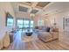 Open concept living room area with tan sofa, sliding glass doors and coffered ceiling at 10308 Malvasia Ave, Riverview, FL 33578