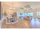 Spacious living room featuring a coffered ceiling, light wood floors, and large windows at 10308 Malvasia Ave, Riverview, FL 33578