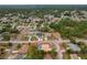 Aerial view highlights community, mature trees and landscaping, and the home's tile roof and screened-in pool at 11411 Terrell, Spring Hill, FL 34606