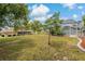 Spacious backyard featuring a well-maintained lawn, screened-in pool, and lush trees at 11411 Terrell, Spring Hill, FL 34606