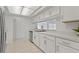 Bright, white kitchen with stainless steel appliances and white tile flooring at 11411 Terrell, Spring Hill, FL 34606