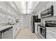 White kitchen with stainless steel appliances, bright lighting, and spacious layout at 11411 Terrell, Spring Hill, FL 34606
