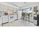 Bright kitchen with white appliances and a cozy breakfast nook overlooking the pool at 11613 Sunshine Pond Rd, Tampa, FL 33635